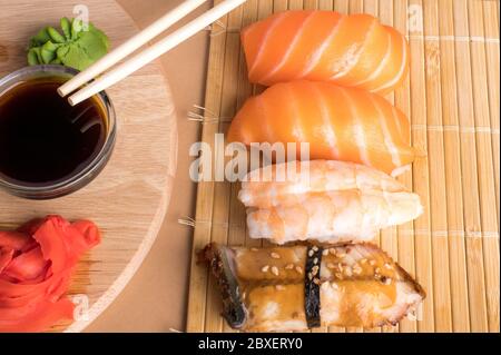 Set di sushi assortiti servito su tappeto di bambù. Vista dall'alto della cucina tradizionale giapponese Foto Stock