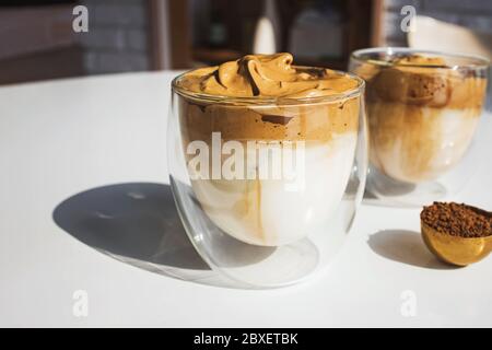 Dalgona Coffee, un caffè frizzante e cremoso alla moda in tazze di vetro Foto Stock