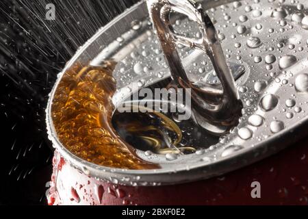 Spruzzare da una bevanda frizzante all'apertura di una lattetta ad anello. Foto Stock