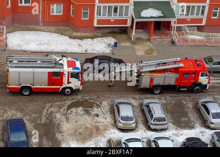 Motore antincendio nel cortile di un edificio residenziale a più piani in inverno. Foto Stock