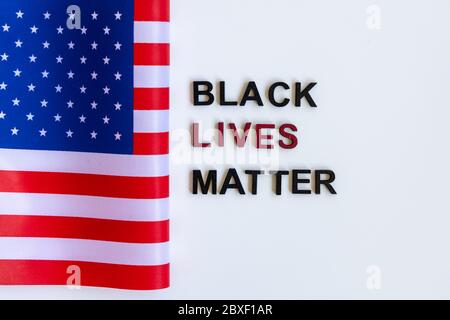 Primo piano slogan Black Lives Matter tag. Protesta clenched nera. Bandiera americana. Foto Stock