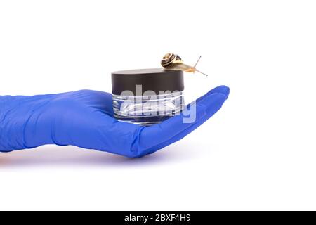 Donna scienziato mano in blu guanti protettivi che tengono vaso di vetro con pelle o crema di riparazione del viso e lumaca isolato su bianco, mockup. Messa a fuoco selettiva. Foto Stock