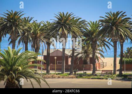 Swakopmund, Namibia - 18 aprile 2015: Un vecchio edificio tedesco circondato da palme Foto Stock