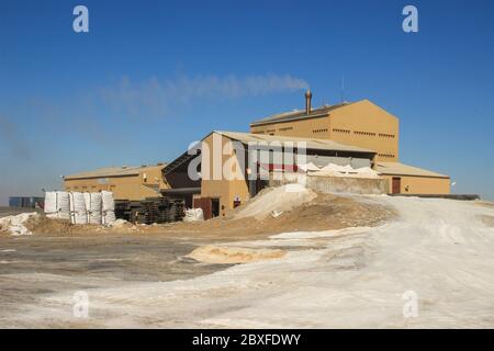 Walvis Bay, Namibia - 25 aprile 2015: Produzione di sale in una fabbrica dall'Oceano Atlantico sulla costa vicino a Walvis Bay, Namibia. Montagne di sale. Foto Stock