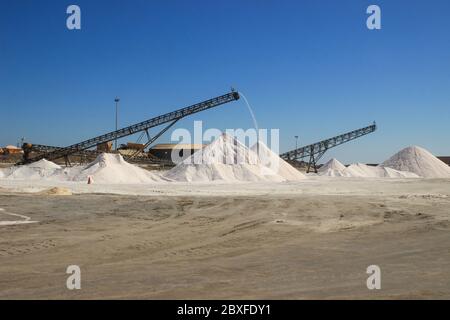 Walvis Bay, Namibia - 25 aprile 2015: Produzione di sale in una fabbrica dall'Oceano Atlantico sulla costa vicino a Walvis Bay, Namibia. Montagne di sale. Foto Stock