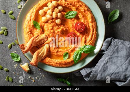 Hummus di pomodoro fatto in casa con grissini e basilico Foto Stock