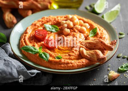 Hummus tradizionale di pomodoro con grissini e basilico Foto Stock