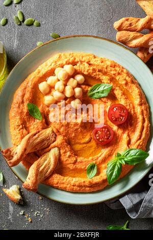 Hummus di pomodoro fresco con olive, basilico e grissini Foto Stock