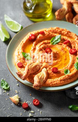 Hummus di pomodoro fresco con grissini e basilico Foto Stock