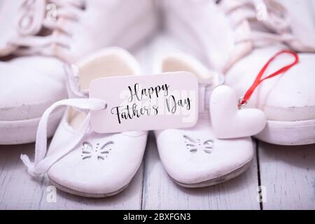 Scarpe uomo e bambino su sfondo bianco di legno. Concetto di giorno del padre felice. Foto Stock