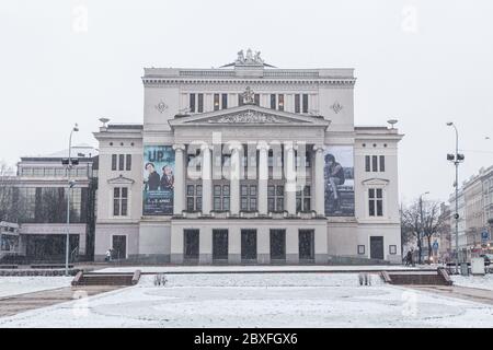 RIGA, LETTONIA - 2 GENNAIO 2017: L'esterno dell'Opera Nazionale Lettone durante il giorno d'inverno. Neve e persone possono essere visti. Foto Stock