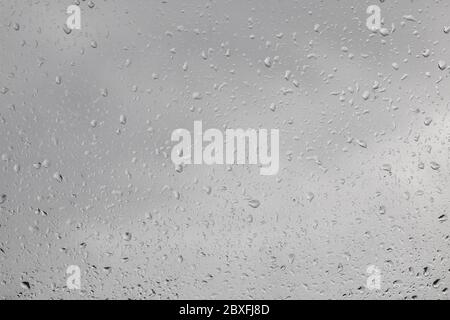 pioggia sulla finestra - vista fuori la finestra verso l'esterno, tempo piovoso, texture sfondo Foto Stock