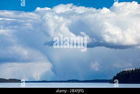 Nuvole lontane che si innalzano dall'orizzonte sul lago ghiacciato Suontee a Winter , Finlandia Foto Stock