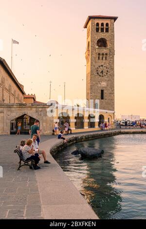Lungomare al tramonto intorno alla Chiesa dell'Annunciazione della Vergine sul porto di Mandraki, Rodi, Dodecanese, Grecia Foto Stock