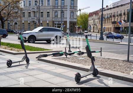 Scooter elettrici in città. Alcuni parcheggiati e altri caduti a terra Foto Stock