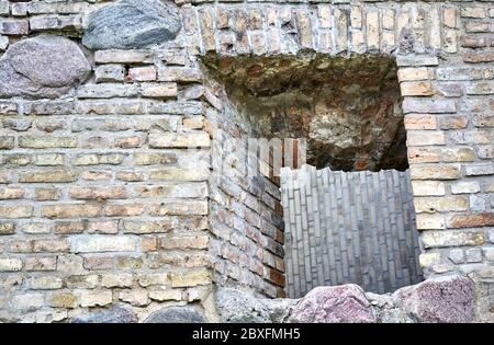 Vecchio muro di mattoni con finestra e nuovo muro di costruzione sullo sfondo Foto Stock