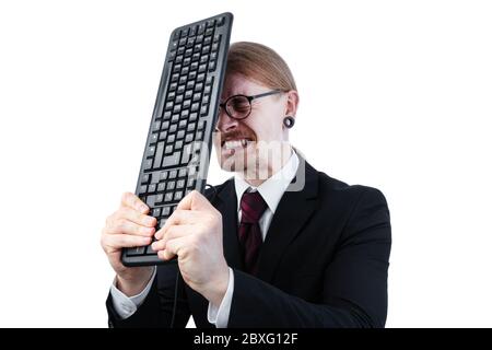 Uomo d'affari con capelli lunghi legati e occhiali che colpiscono la testa con tastiera Foto Stock