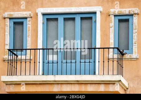 Porte e finestre dipinte di blu e decorate con cornice bianca. Foto Stock