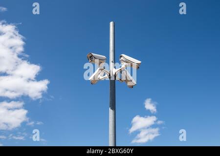 Telecamere panoramiche di sorveglianza su colonna alta per la sicurezza in ambiente pubblico. Cielo blu sullo sfondo. Concetto di osservazione, monitoraggio e protezione dei dati Foto Stock