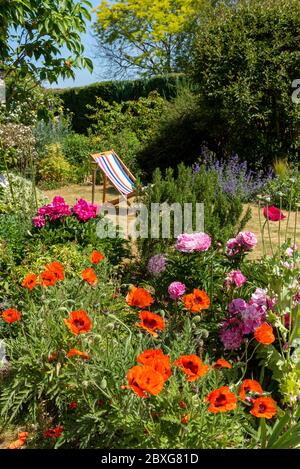 Nord Hampshire, Inghilterra, Regno Unito. Maggio 2020. Un grazioso giardino di campagna inglese e una sedia a sdraio all'inizio dell'estate. Hampshire, Inghilterra, Regno Unito. Foto Stock
