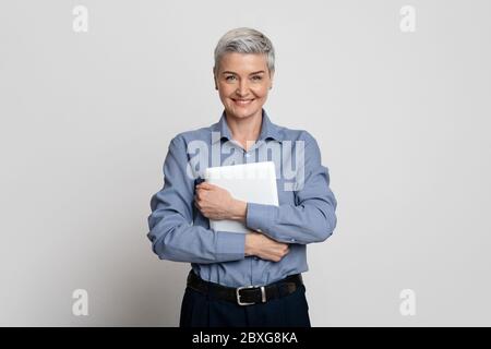 Ritratto di imprenditore femminile di media età positivo con Tablet digitale in mani Foto Stock