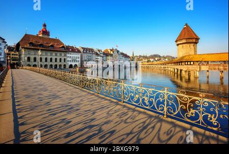 Lucerna, Svizzera, ombre ornate, gettate da balaustre decorate sul ponte pedonale nel centro storico in una giornata di sole Foto Stock