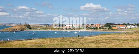 Vista sul porto e la baia verso le rovine priorate e il villaggio di Lindisfarne, Northumberland Foto Stock