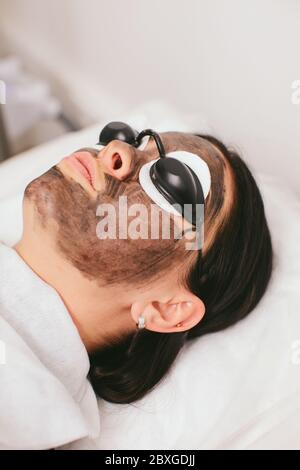 Donna che ha un trattamento di bellezza di buccia di carbonio Foto Stock
