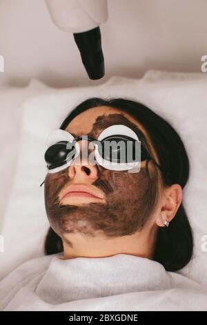 Donna che ha un trattamento di bellezza di buccia di carbonio Foto Stock
