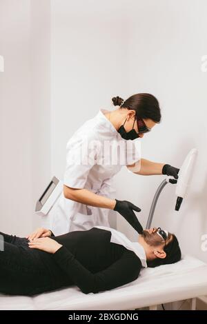 Donna che ha un trattamento di bellezza di buccia di carbonio Foto Stock