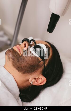 Donna che ha un trattamento di bellezza di buccia di carbonio Foto Stock