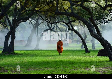 Monaco che cammina attraverso il Parco storico di Ayutthaya all'alba, Pratu Chai, Thailandia Foto Stock