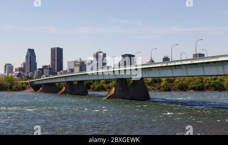Una vista del centro cittadino di Montreal durante il giorno mostra il Pont de la Concorde bridge, edifici e uffici. Foto Stock