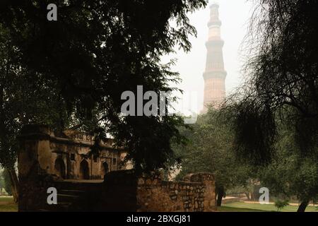 Dawn solleva i terreni del complesso Qutb Minar e le rovine sulla mattina nebbiosa a Delhi, India. Foto Stock
