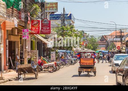 SIEM REAP, CAMBOGIA - 28 MARZO 2017: Strade di Siem Reap in Cambogia durante il giorno, mostrando l'esterno di negozi, persone e tuk tuk. Foto Stock