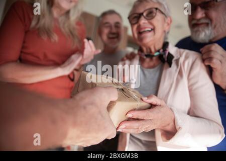 felice vecchia donna che accetta le congratulazioni dai suoi amici . Foto Stock