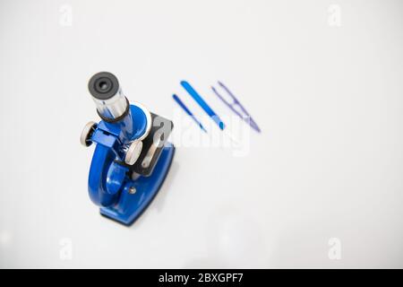 microscopio isolato su sfondo bianco con strumenti di ricerca Foto Stock