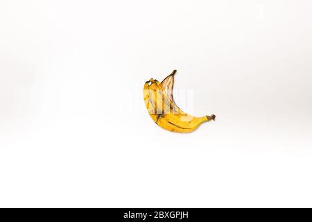 buccia di banana rovinata su uno sfondo bianco isolato Foto Stock