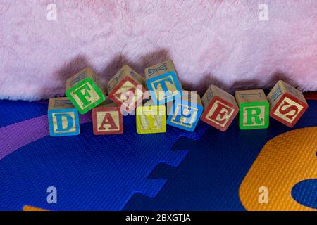 messaggio del giorno dei padri scritto con le lettere del blocchetto di legno dei bambini sul tappeto di gioco di un bambino Foto Stock