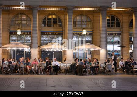 Parigi, Francia - 21 settembre 2019: Persone che riposano su una terrazza di strada di un caffè le Nemours. Situato vicino alla Comedie Francaise e al Palais Royal, il caffè è popolare tra i turisti e la gente del posto Foto Stock