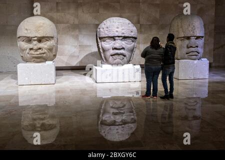 Visita turistica colossale teste di pietra Olmec al Museo di Antropologia nel centro storico di Xalapa, Veracruz, Messico. La civiltà Olmec fu la prima civiltà mesoamericana conosciuta, che risale approssimativamente dal 1500 a.C. a circa 400 a.C.. Foto Stock