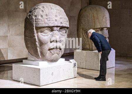 Visita turistica colossale teste di pietra Olmec al Museo di Antropologia nel centro storico di Xalapa, Veracruz, Messico. La civiltà Olmec fu la prima civiltà mesoamericana conosciuta, che risale approssimativamente dal 1500 a.C. a circa 400 a.C.. Foto Stock