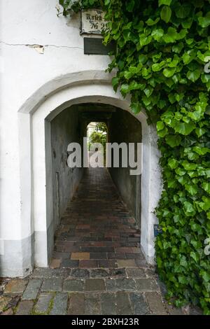 Stretto tunnel d'ingresso ad un piccolo vicolo residenziale, tipica destinazione turistica nel centro storico medievale di Lubecca, Germania, fuoco selezionato Foto Stock