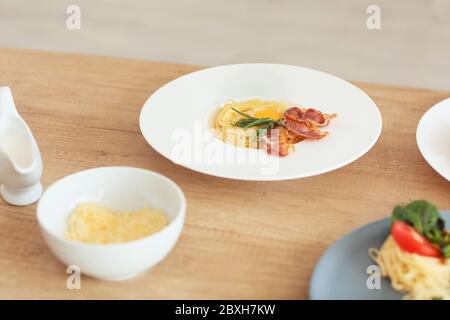 Piatto con gustosa pasta carbonara sul tavolo in cucina Foto Stock