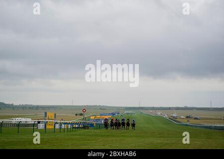 Una visione generale mentre i corridori passano il posto vincente all'Ippodromo di Newmarket. Foto Stock