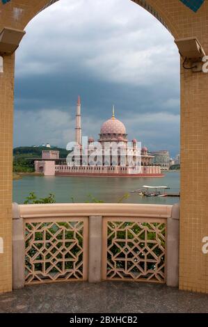 Masjib Putra moschea in putrajaya, Malesia, Asia vicino al lago e vista attraverso una cornice ad arco Foto Stock