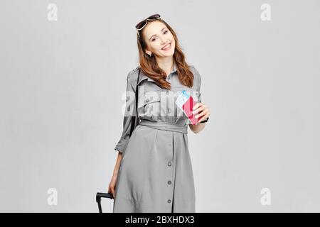 Ragazza gioiosa con biglietti aerei e bagagli Foto Stock