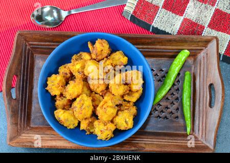 Il pakora, chiamato anche pakoda, è un popolare spuntino fritto indiano e anche il cibo preferito di strada. Foto Stock