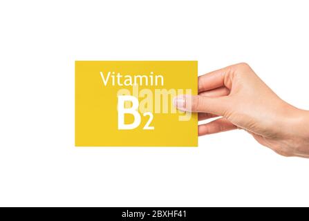 La mano femminile mostra una scheda con l'iscrizione Vitamina B2. Vitamina B2. Foto Stock