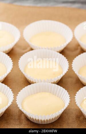 Impasto di cupcake in stampi di carta. Dolci preparati per la cottura. Dessert per feste Foto Stock